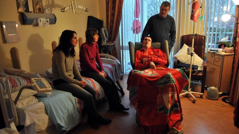 Shane Grogan with his father Joe, mother Joan and sister Sarah:  The 28 year old is learning how to use his index finger to communicate.  Photograph: Ray Ryan