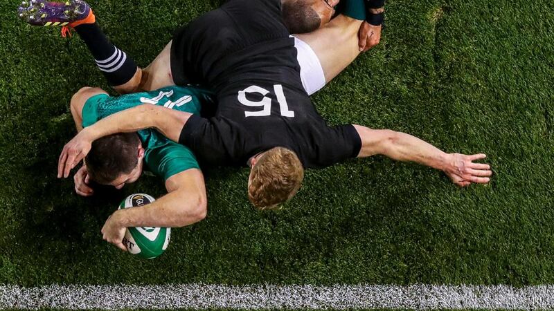 Jacob Stockdale gets over for a try despite the best attempts of  Damian McKenzie and Aaron Smith of New Zealand during the November international in 2018 at the Aviva stadium. Photograph: Tommy Dickson/Inpho