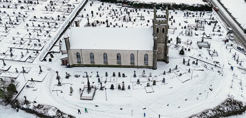 People make their way through snow to mass at Holy Cross Catholic Church in Killeshin, Co Laois. Photograph: Niall Carson/PA Wire