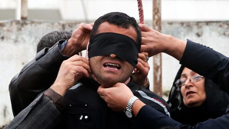 The mother (R) of murder victim Abdolah Hosseinzaderemoving the rope from Balal (C), who was convicted and sentenced to death for killing her son, during the execution in the northern city of Nowshahr, Iran on Tuesday. Photograph: Arash Kamooshi/EPA
