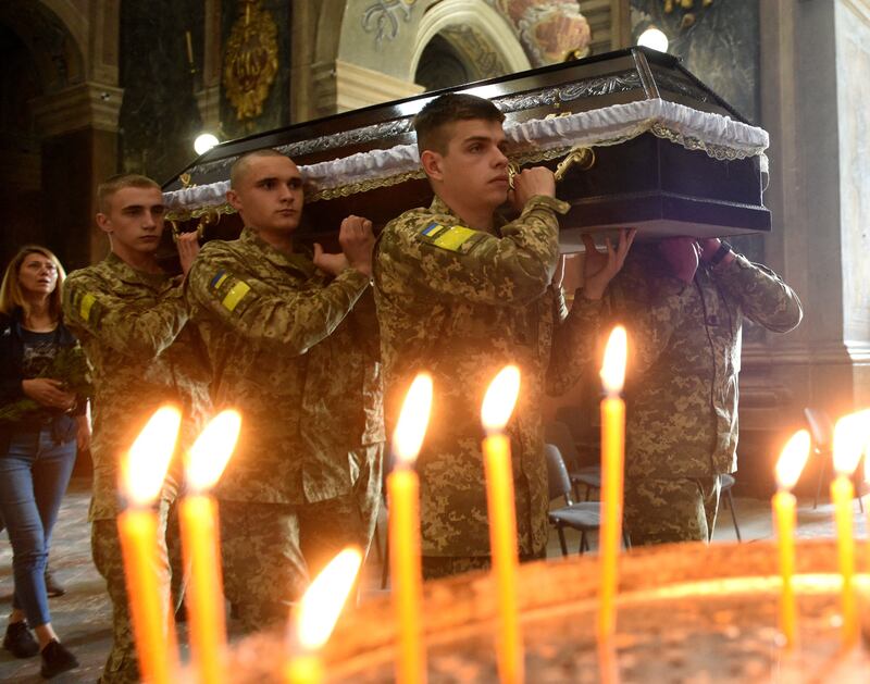 Ukrainian soldiers carry the coffins of two Ukrainian servicemen killed in action at the Saints Peter and Paul garrison church in a city of Lviv. Photograph:  Yuriy Dyachyshyn / AFP