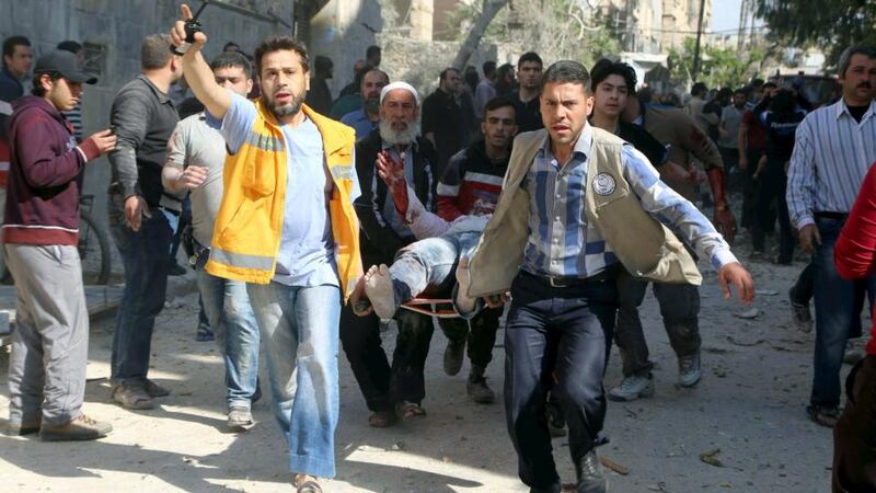 Men and civil defence members carry an injured man on a stretcher after what activists said was a barrel bomb dropped by forces loyal to Syria’s president Bashar al-Assad and hit a school and a residential building in Seif al-Dawla,  Aleppo . Photograph: Hosam Katan/Reuters