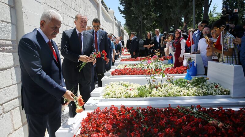 Turkish president Tayyip Erdogan and prime minister Binali Yildirim visit graves of civilians killed during last year’s failed coup in Istanbul, Turkey. Photograph: Kayhan Ozer/Presidential Palace