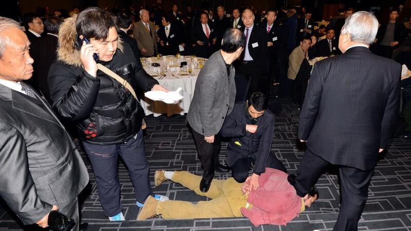 This handout photo taken and released on March 5, 2015 by South Korean local newspaper the Asia Economy Daily shows the man  who attacked US ambassador to South Korea Mark Lippert, being detained by police at the Sejong Cultural Institute in Seoul. Photograph: The Asia Economy Daily/The Asia Economy Daily/AFP Photo