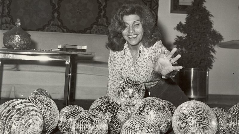 Monir Shahroudy Farmanfarmaian in her salon 1975, Tehran, Bukhara (Turkoman textile) in background. Courtesy of the artist and The Third Line, Dubai