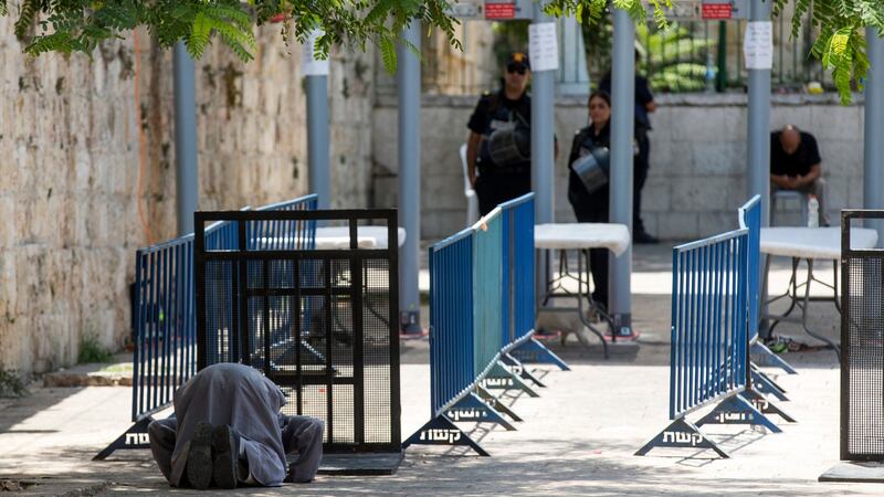 Palestinian worshiper prays in front of the metal detectors at the entrance to the Al-Aqsa compound, in Jerusalem. Photograph: Atef Safati/EPA