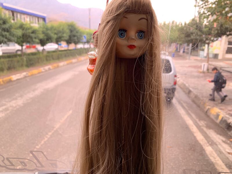 A doll's head, symbolic of Mahsa Amini’s arrest, hung from the rearview mirror of the bus carrying Iranians to Iraqi Kurdistan. Photograph: Lorraine Mallinder