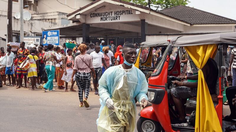 People look after family members outside the Connaught Government Hospital in Freetown. Photograph:  Saidu Bah/AFP via Getty Images