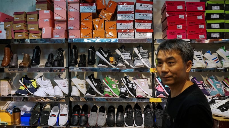 A Chinese salesman sells copies of various American footwear brands inside a shopping complex in Shanghai. Beijing has warned it “will not sit idle” if a US probe into its intellectual property practices leads to sanctions. Photograph: Chandan Khanna/AFP/Getty Images