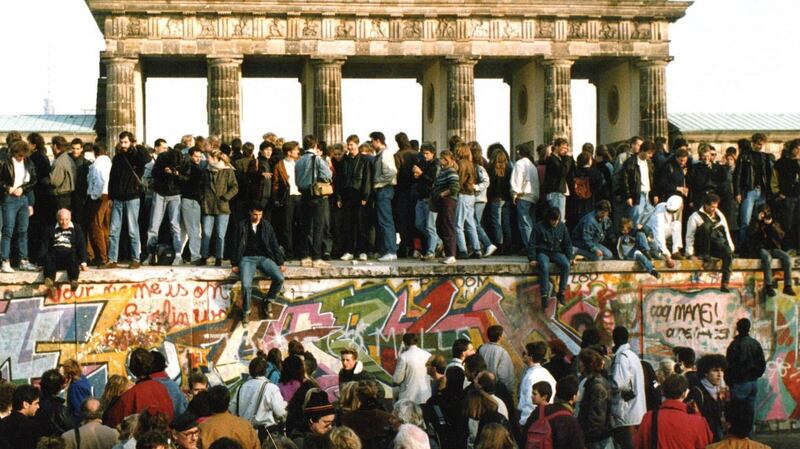 Germans from east and west stand on the Berlin Wall in front of the Brandenburg Gate, a  day after the wall opened. File photograph: AP