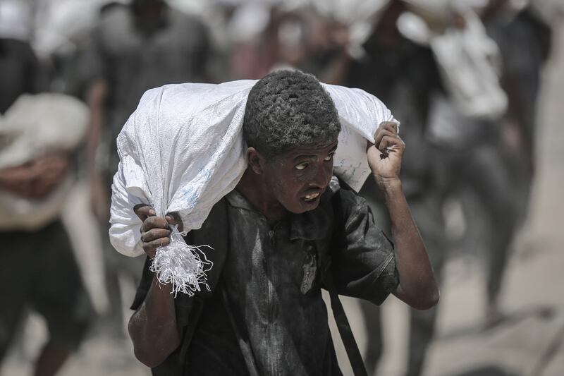 A Palestinian carrying a sack of food which entered Gaza through Israel in Beit Lahia, northern Gaza, on Sunday. As the aid curbs were rolled back, the Israeli government and military said it had not abandoned its goals of destroying Hamas and releasing the hostages. Photograph: Ahmad Salem/Bloomberg
