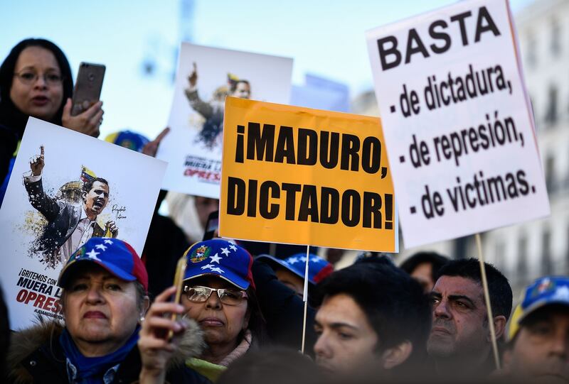 People hold placards reading ‘Maduro, dictator!’ and ’Enough of dictatorship, represion and victims’ during a demonstration called by Venezuelan citizens against Maduro on January 13th in Madrid, Spain. Photograph: Oscar Del Pozo/AFP/Getty