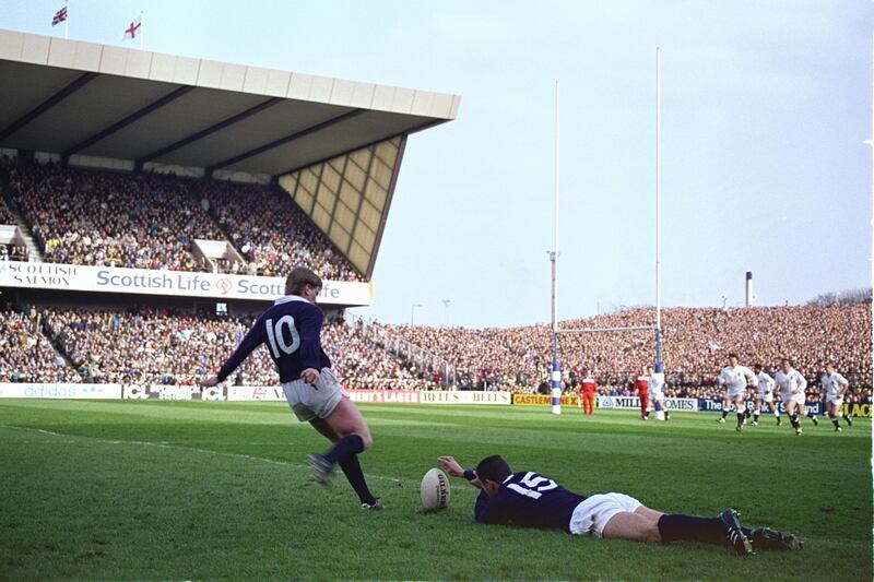 Scotland's Craig Chalmers kicking into the wind, with the aid of teammate Gavin Hastings, during the 1990 Grand Slam decider against  England at Murrayfield. The game was fired up by poisonous resentment towards Thatcher’s poll tax. Photograph: Allsport