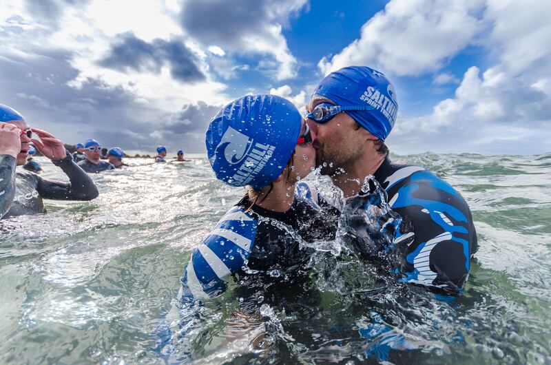Two swimmers kissing before heading out to open water during the triathlon in Salthill in Galway. Photograph: Martin Kalvaster