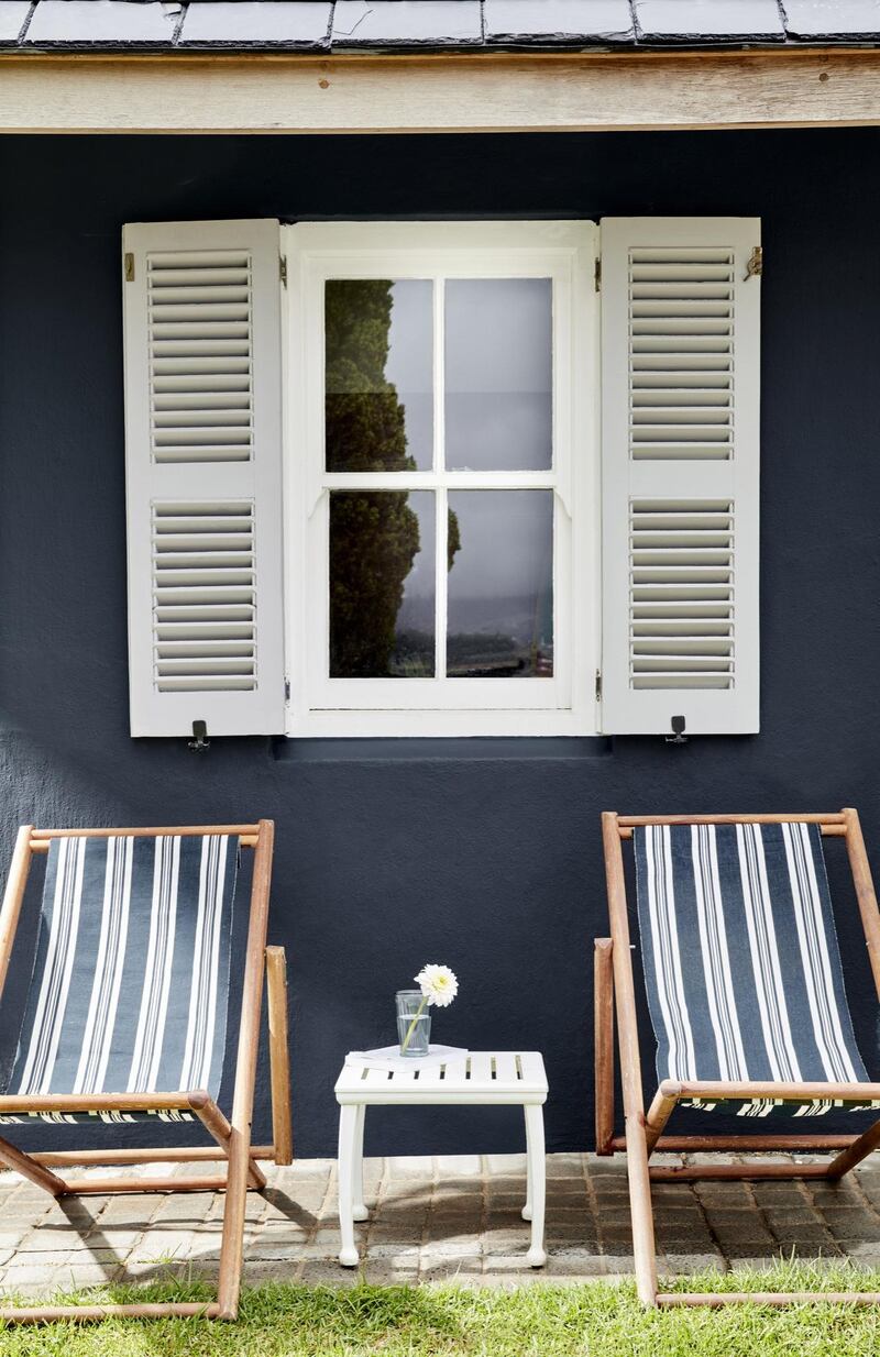 Folding deck chairs, such as those pictured that tonally match Little Greene’s Obsidian exterior paint, also make sense