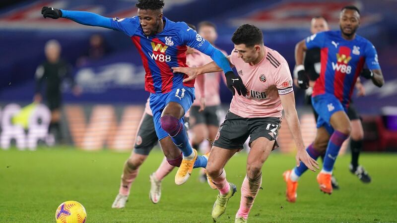 John Egan tussles with Wilfried Zaha during Sheffield United’s defeat to Crystal Palace. Photograph: John Walton/Getty
