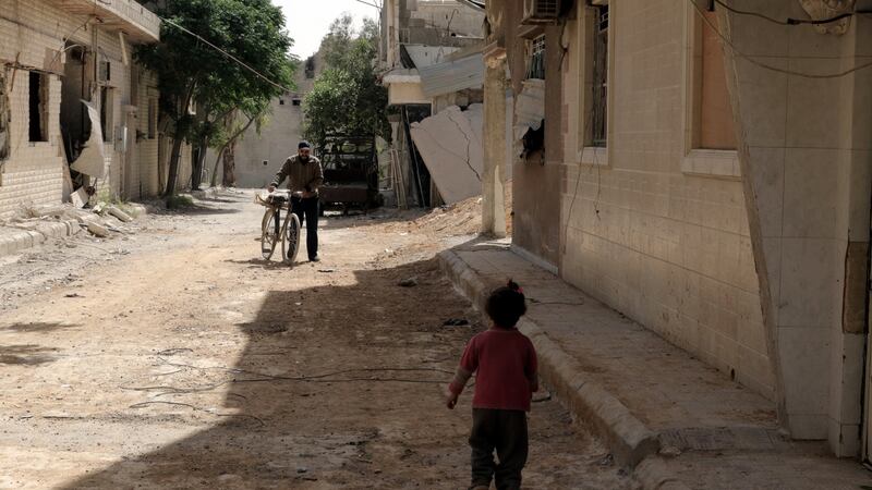 People walk in the recently recaptured Douma, on the outskirts of Damascus, Syria. Photograph: Youssef  Badawi/EPA