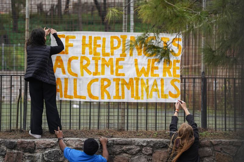 Supporters of the 24 aid workers and volunteers display a banner outside the court on Tuesday. Photograph: Panagiotis Balaskas/AP