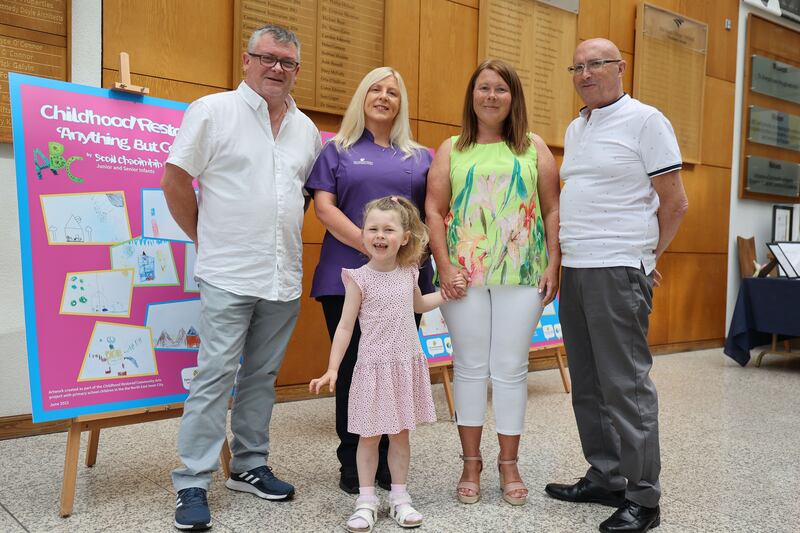 From left, Paul Arnold, home visitor Deirdre Bates, four-year-old Kate Arnold, Tracey McGaughren and Kate's grandad, Tony McGaughren, from Crumlin, gather for the graduation ceremony in the National College of Ireland.  Photograph: Nick Bradshaw 