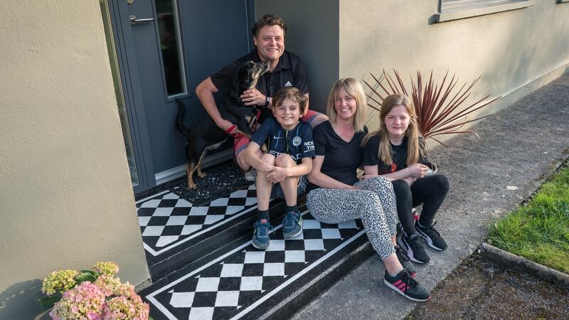 Karen Cafferky with her husband Joe Hurl and children Autumn, aged 13 and Ethan aged 11 and dog Harry sitting on the front doorstep  Karen painted  to look like black and white chequered tiles, in   Ballaghaderreen, Co Roscommon. Photograph: Keith Heneghan