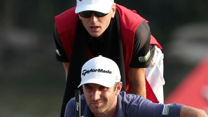 Dustin Johnson  and his caddy look over his putt on the 18th green during the second round of the WGC-HSBC Champions  in Shanghai. Photo: Aly Song/Reuters