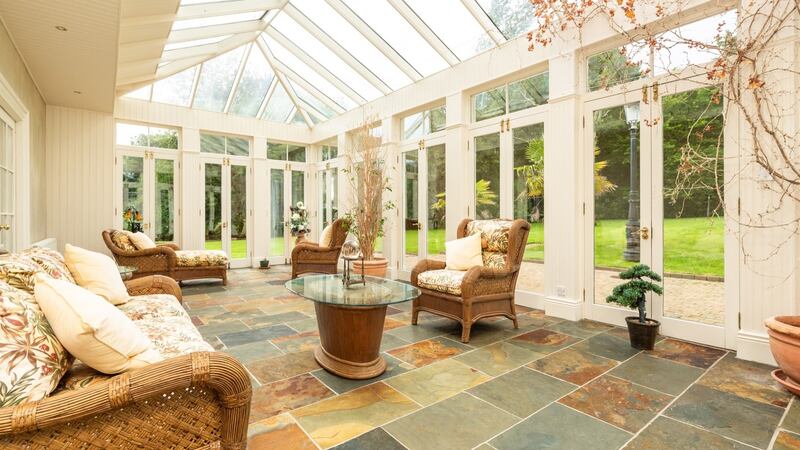 Sunroom where French doors open to the well-landscaped grounds