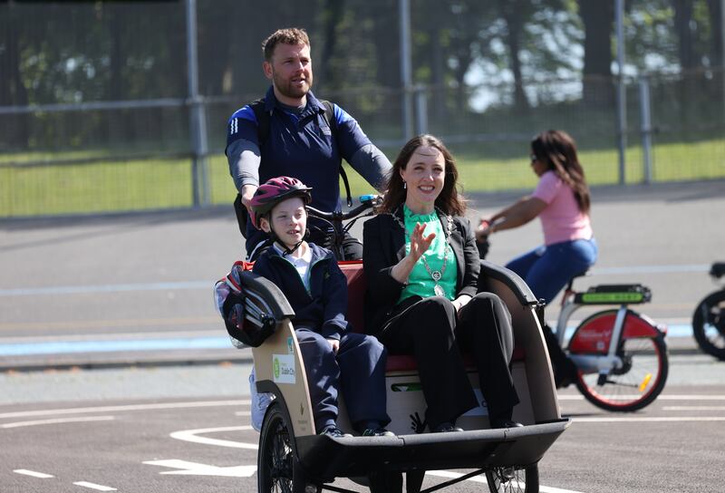 Luke Flynn (10), a pupil of nearby Scoil Iosagáin, and Cllr Fiona Connelly are taken for a spin by Mark  Hughes, Dublin City Council sports inclusion and integration officer, at the new mobility school at Eamonn Ceannt Park, Crumlin.  Photograph: Bryan O’Brien/The Irish Times 

