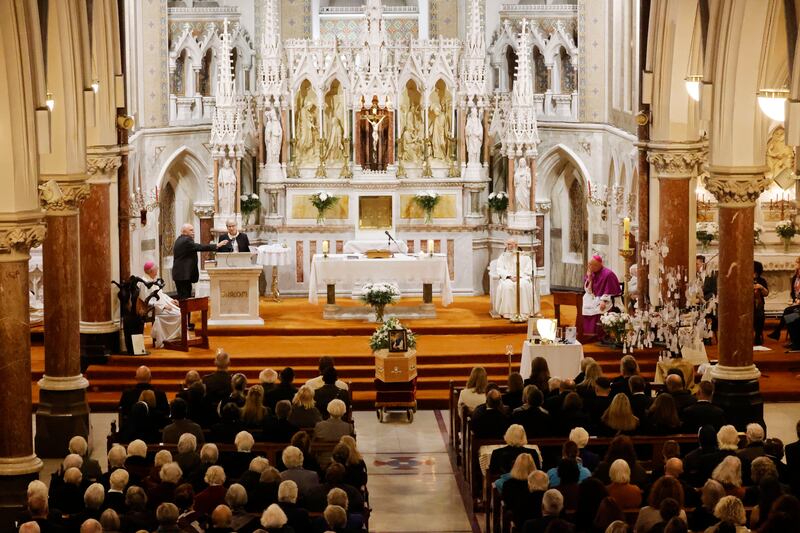 Mourners at the funeral Mass listen intently. 

