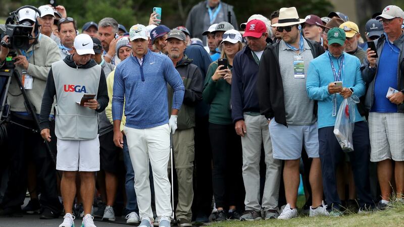 Brooks Koepka lines up a shot from the cart path on the 18th. Photo: Warren Little/Getty Images