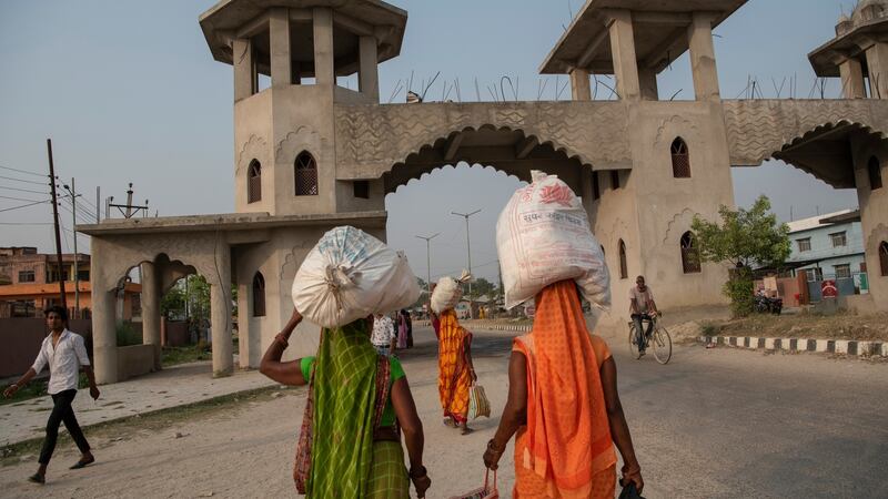 Women carry groceries bought in India back to Nepal, at a border between the two nations.  Photograph: Saumya Khandelwal/The New York Times)