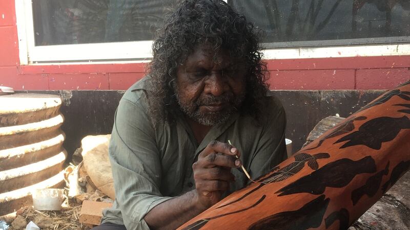 A craftsman works on a digereedoo at Injalak Arts Cetnre