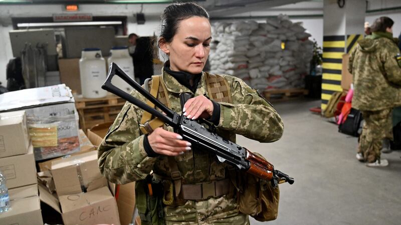 Iryna Sergeyeva, Ukraine’s first female volunteer fighter to get a full military contract from the Ukrainian military reserve, holds her Kalashnikov machine-gun in Kyiv on Friday as she attends a military training in an underground garage  converted into a training and logistics base. Photograph: Sergei Supinsky/AFP via Getty