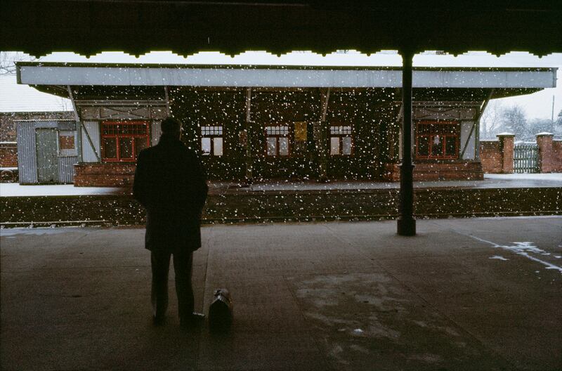 A man waits on a railway platform in Antrim train in the 1970s.