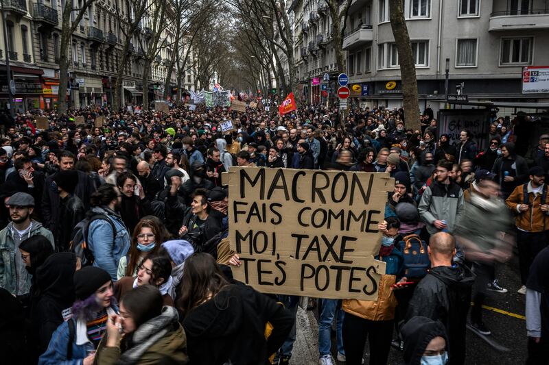 A protester holds a banner reading 'Macron do what I do, tax your friends' during a demonstration against the French president's pension reforms in Lyon on Thursday. Photograph: Jeff Pachoud/AFP via Getty Images