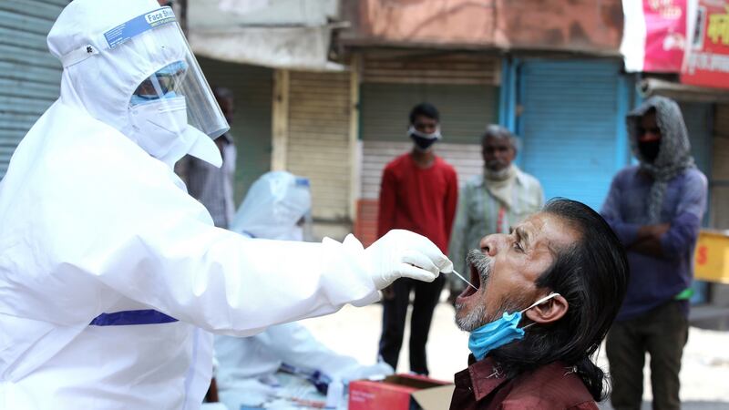 An Indian doctor takes samples from a worker during Covid-19 routine testing at a local market  in Bhopal, India. Photograph: EPA/Sanjeev Gupta