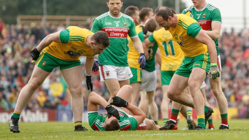 Patrick McBrearty and Michael Murphy argue with an injured Aidan O’Shea of Mayo. Photograph: James Crombie/Inpho