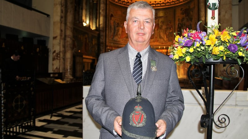 Retired garda Gerry Carter holding a RIC constable hat symbolising his grandfather Tommy Carter’s service in the force. Photograph: Ronan McGreevy