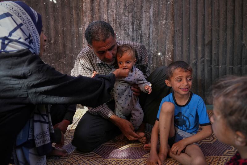 Wedad Abdelaal and her husband Ammar feed their nine-month-old son Khaled in their tent at a camp for displaced Palestinians in Mawasi Photograph: Abdel Kareem Hana/AP