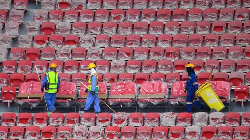 Construction workers at the stands of Qatar’s new al-Bayt Stadium in the capital Doha. Thousands of migrant workers have died during construction of stadiums for the World Cup. Photograph:  Giuseppe Cacace/AFP via Getty
