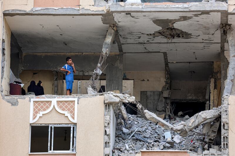 A boy stands in a heavily-damaged room near rubble in one of the damaged buildings at a residential complex in northwestern Khan Younis, in the southern Gaza Strip, on September 22, 2025. Photograph: Omar Al-Qattaa/ AFP via Getty Images 