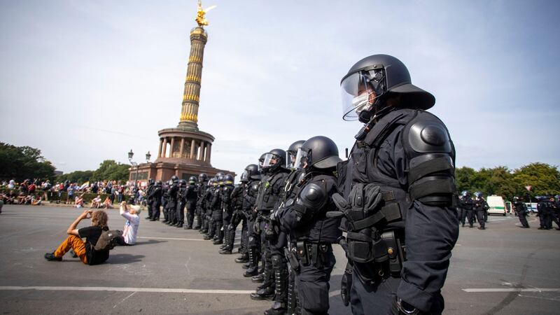 Police officers stand in front of the Victory Column during a protest against the Corona measures in Berlin,on Saturday. Photograph: Christoph Soeder/dpa via AP
