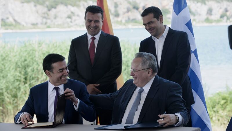 Greek foreign minister Nikos Kotzias (down, R) and his Macedonian counterpart Nikola Dimitrov (down, L) sign a preliminary accord as Greek prime minister Alexis Tsipras (R) and Macedonian prime minister Zoran Zaev stand behind, on the shore of the Lake Prespa. Photograph: Sakis Mitrolidis/AFP/Getty Images