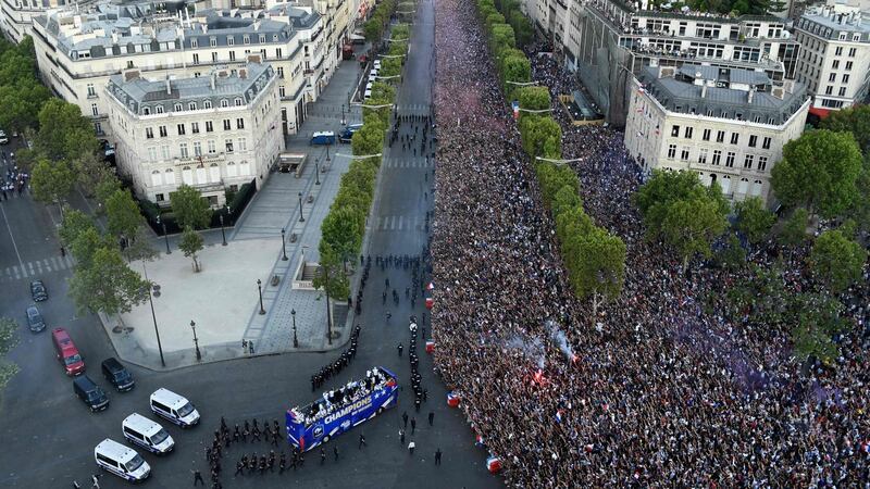 An aerial view of fans greeting France’s national soccer team  as they parade on a bus down the Champs-Élysée  in Paris. Photograph: Bertrand Guay/AFP/Getty Images