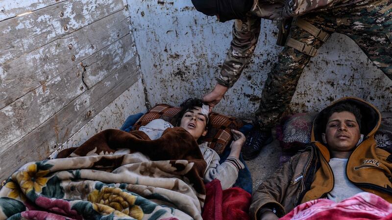 Members of the Kurdish-led Syrian Democratic Forces tend to injured boys after leaving the Islamic State (Isis) group’s last holdout of Baghouz. Photograph: Getty Images