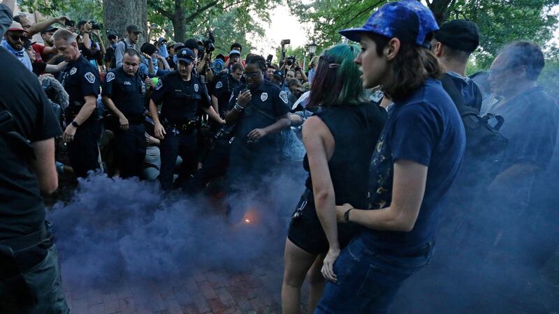 Police and protesters react to a smoke bomb during a rally to remove the confederate statue known as Silent Sam from campus at the University of North Carolina. Photograph: Gerry Broome/AP