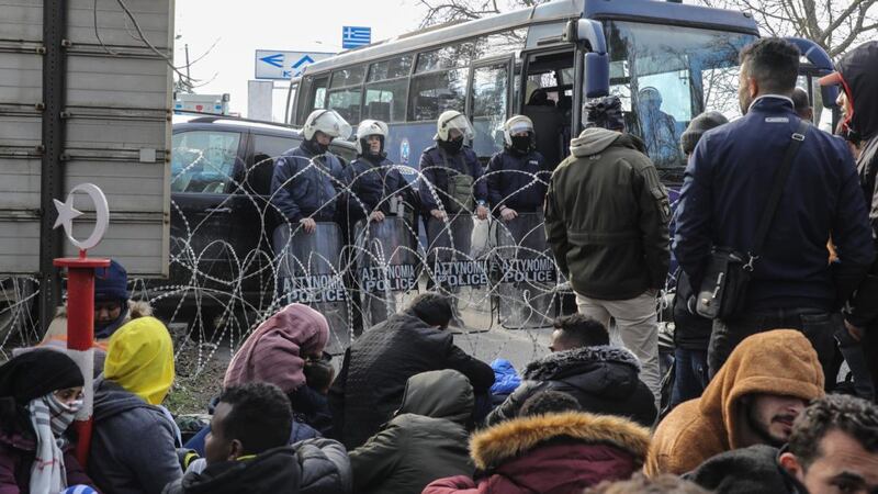 Greek border security guards stand in front of refugees trying to cross the border on Friday in Edirne, Turkey. Photograph:  Osman Orsal/Getty Images