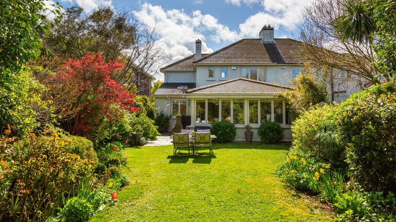 The rear garden is sheltered by mature trees.