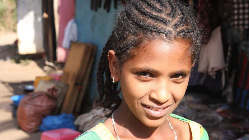 Meron, 11, standing in front of the clothes store where she works.  Photograph: James Jeffrey