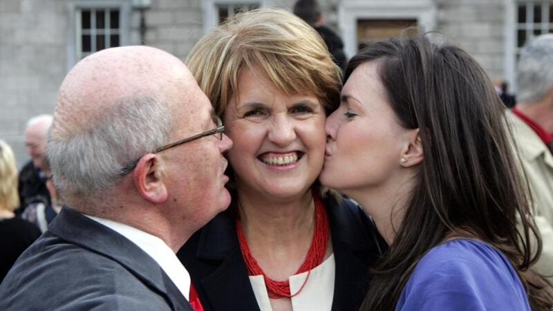 Joan Burton is embraced by  husband Pat Carroll and daughter Aoife at the opening of the 31st Dáil in Leinster House in 2011. Photograph : Matt Kavanagh