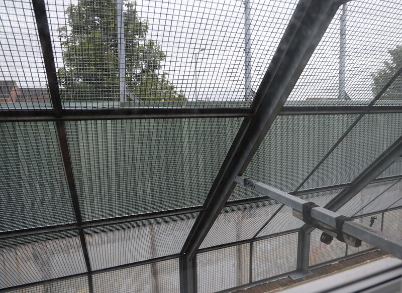 Feet from the edge of the Peace Wall,  a  protective metal cage, behind the home of Jean Canavan protects her back yard area in Bombay Street. Photo: Bryan O’Brien 
